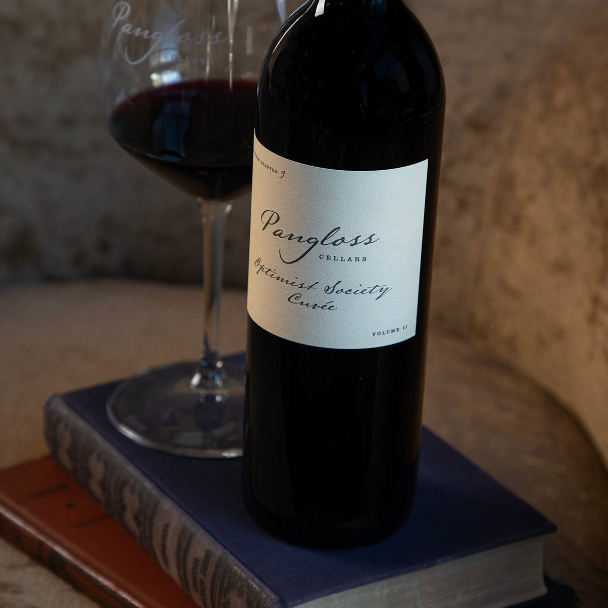 Pungloss wine bottle with a glass of red wine on a textured surface
