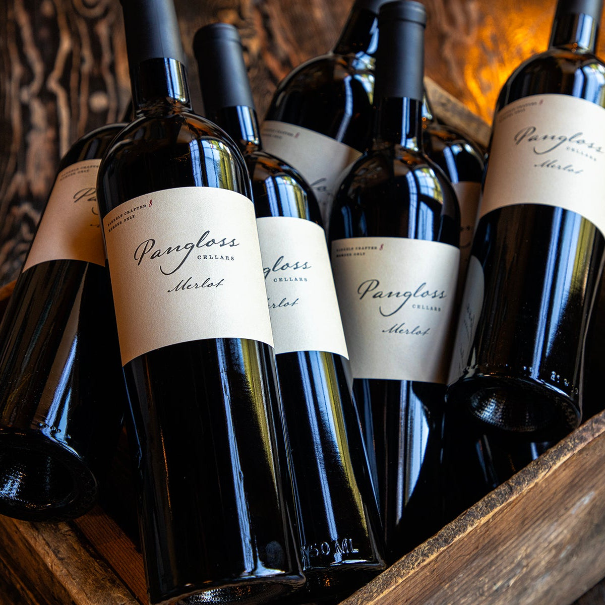 Wine bottles in a wooden crate with 'Pangloss' labels.
